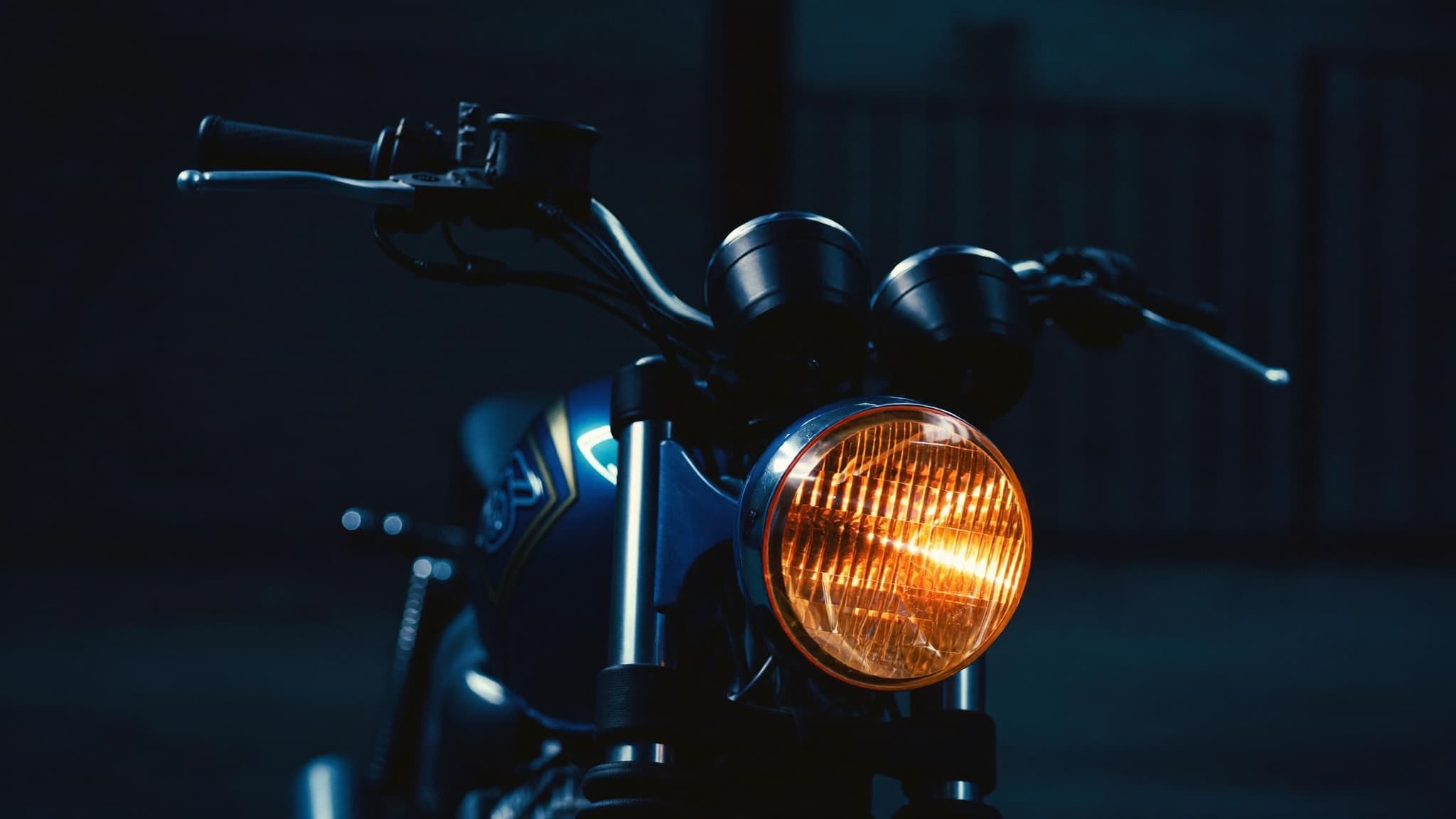 Motorcycle headlight glowing in a dark showroom